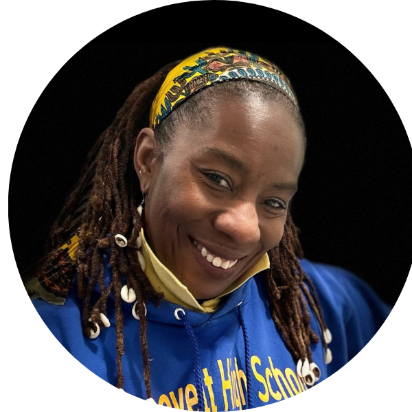 Smiling person in a blue hoodie and colorful headband against a black background