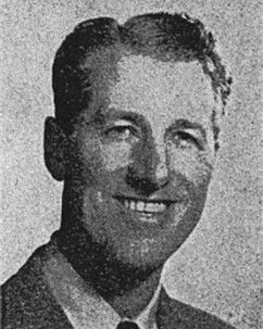 Black-and-white portrait of a smiling man in a suit and tie.