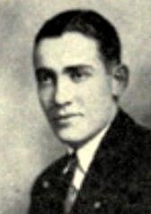 Black-and-white portrait of a man in a suit and tie against a plain background