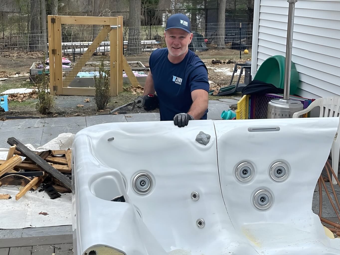 A man is standing next to a white hot tub.