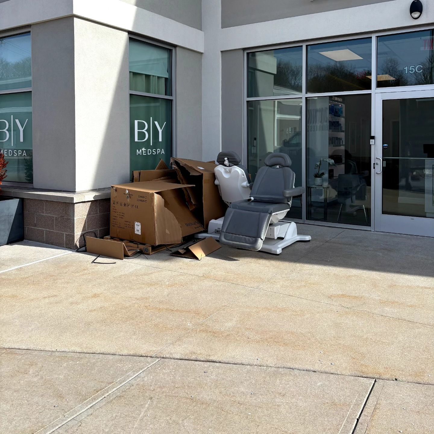 A chair is sitting in front of a building that says by