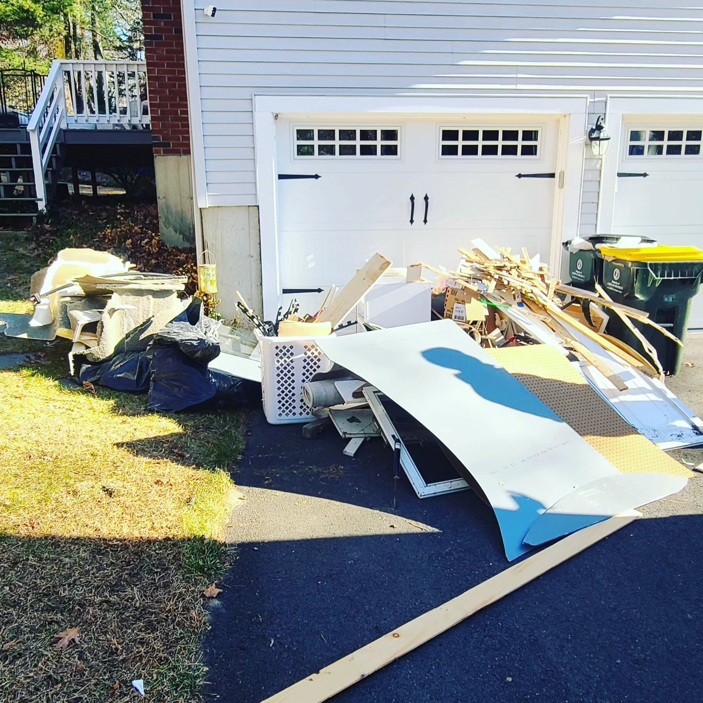 A pile of garbage sits in front of a garage door