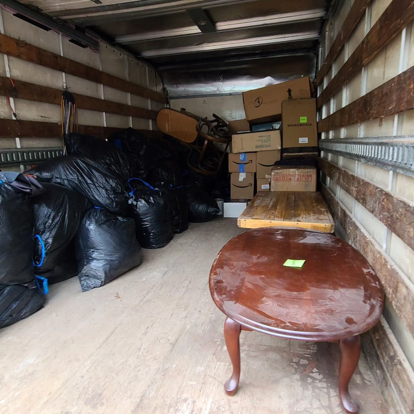 The inside of a moving truck filled with boxes and bags