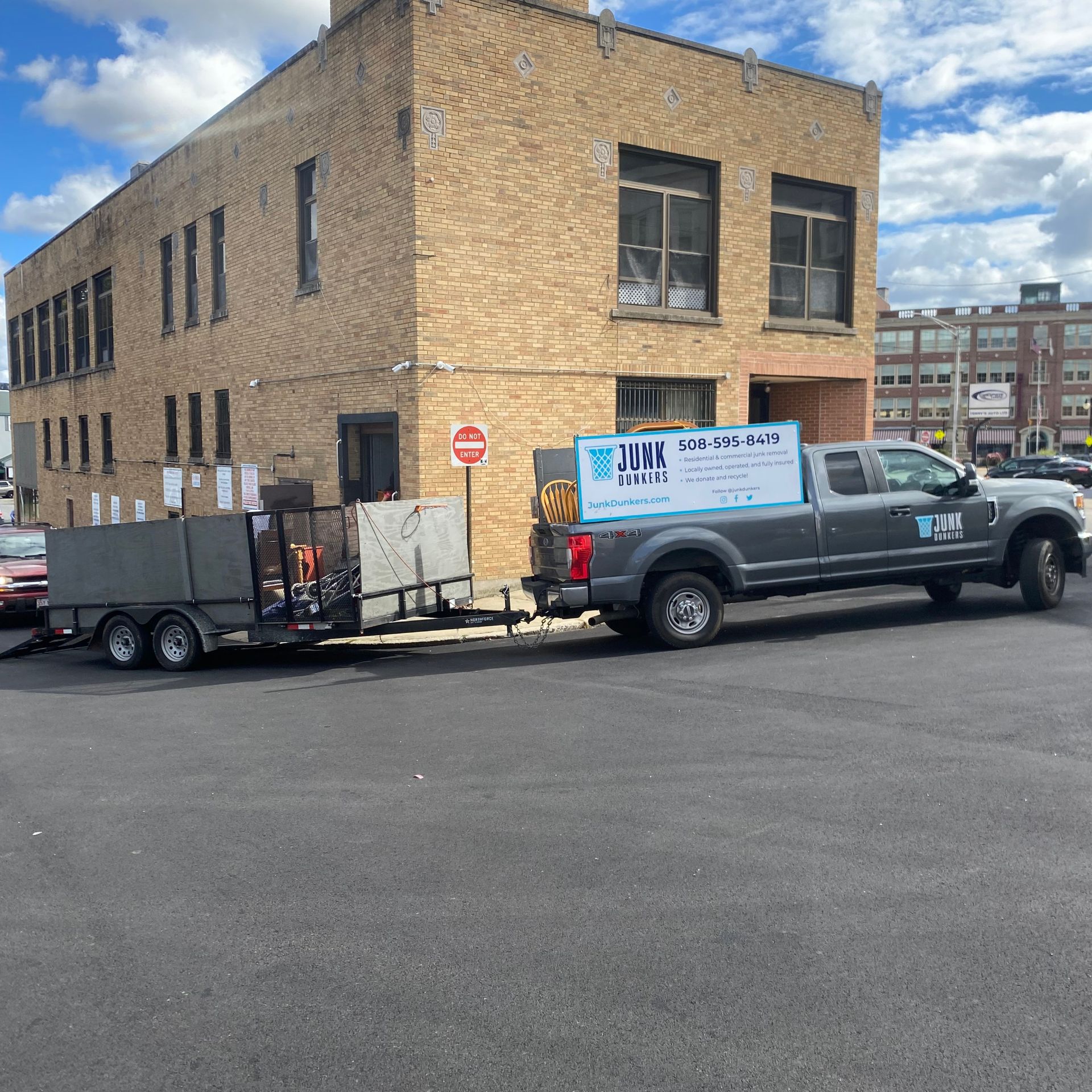 A truck with a trailer attached to it is parked in front of a building.