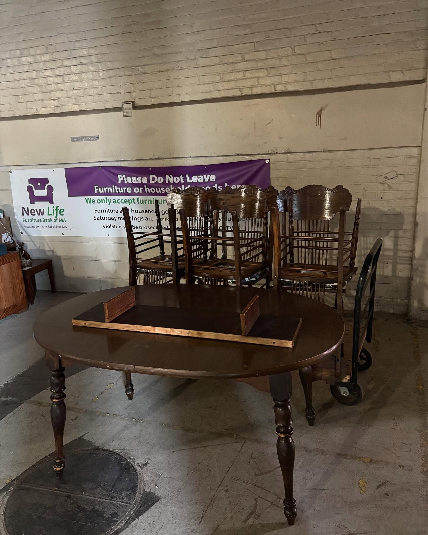 A table and chairs are sitting in a room with a sign that says home do not leave.