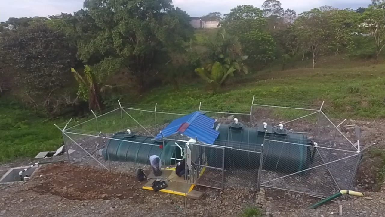 Un grupo de personas está trabajando en un tanque grande en un campo.