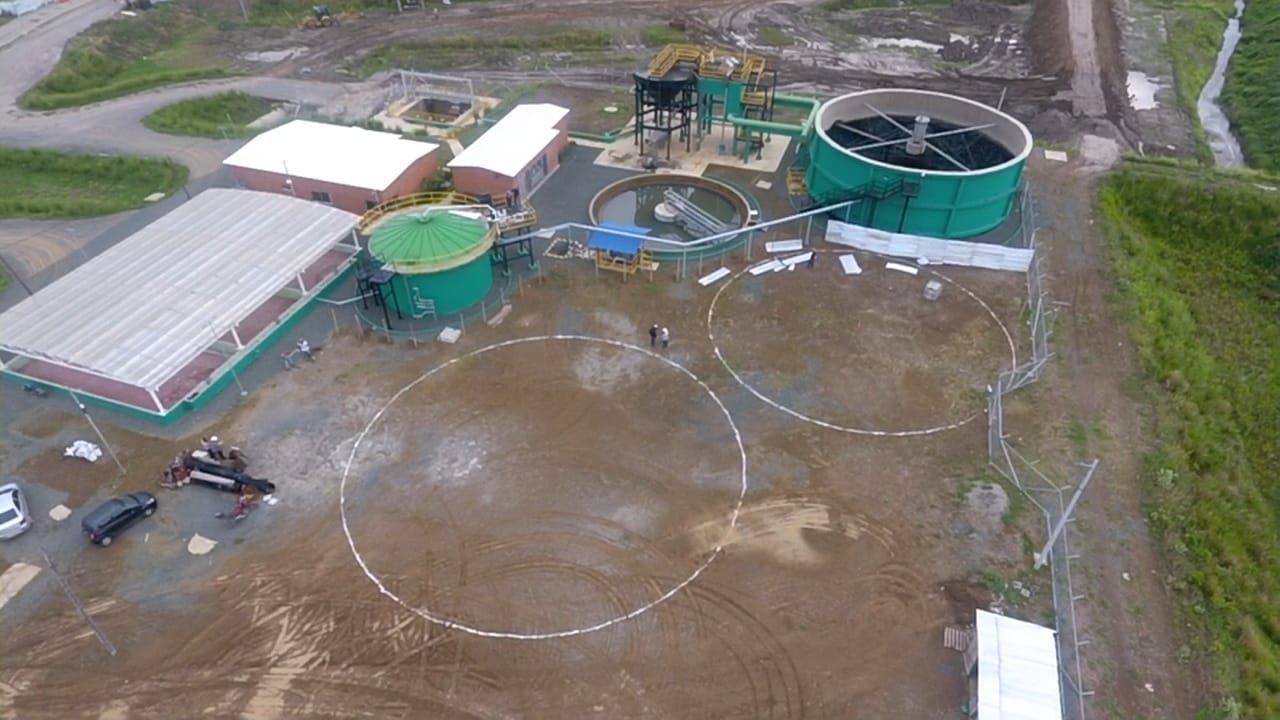Una vista aérea de una planta de tratamiento de agua con un gran tanque verde en el medio.