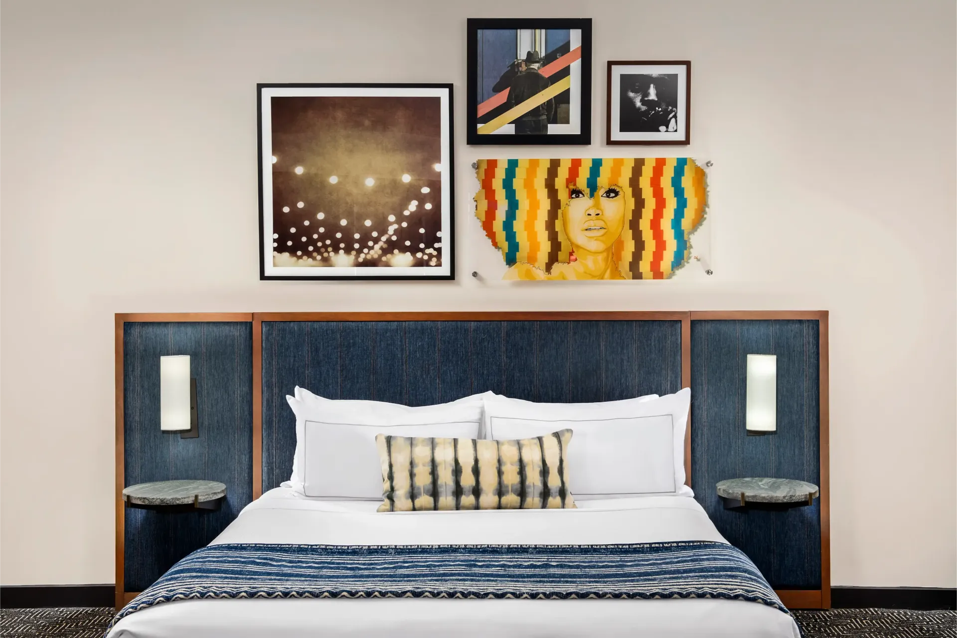 A hotel room with a bed and paintings on the wall.