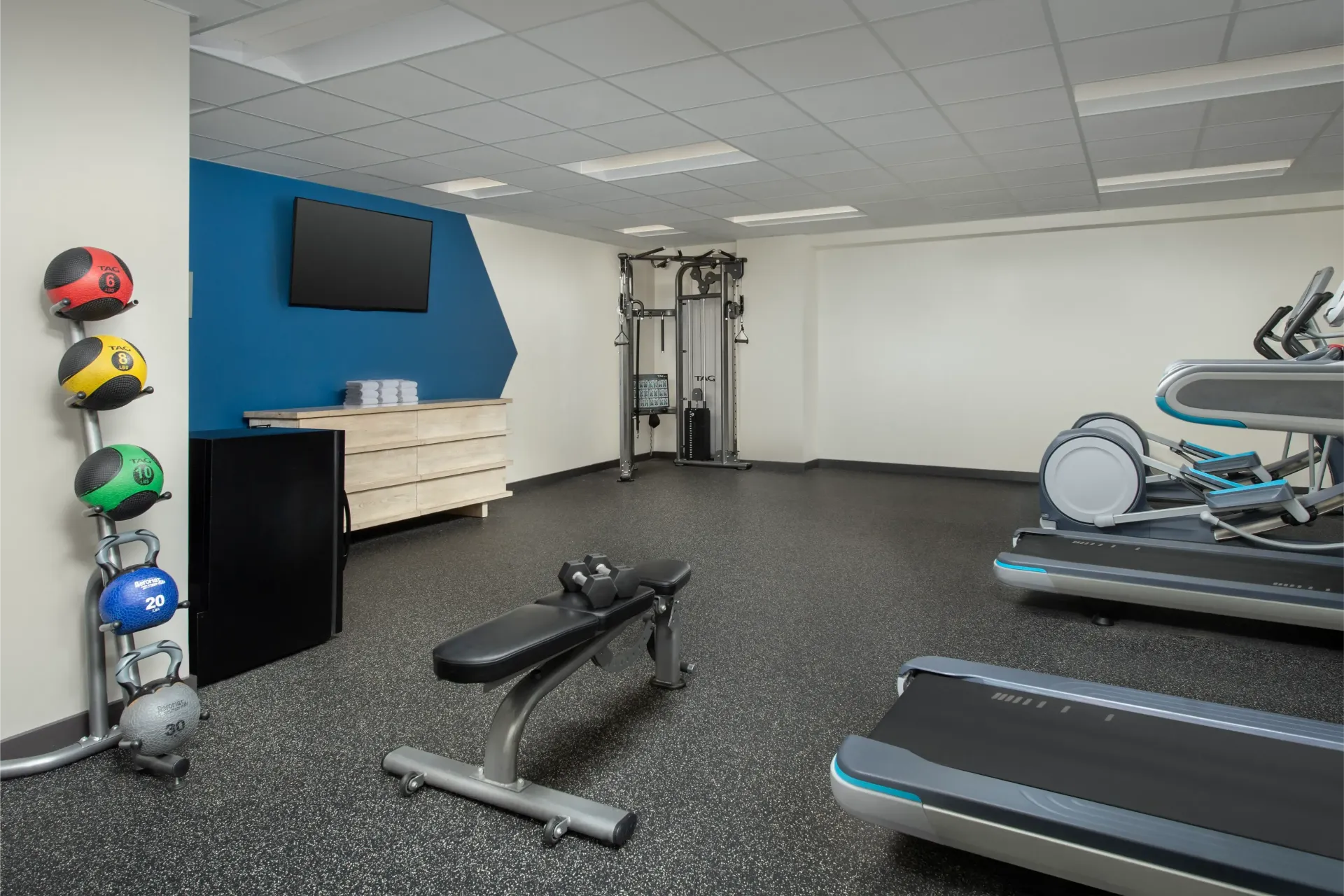 There is a treadmill and a bench in the gym.