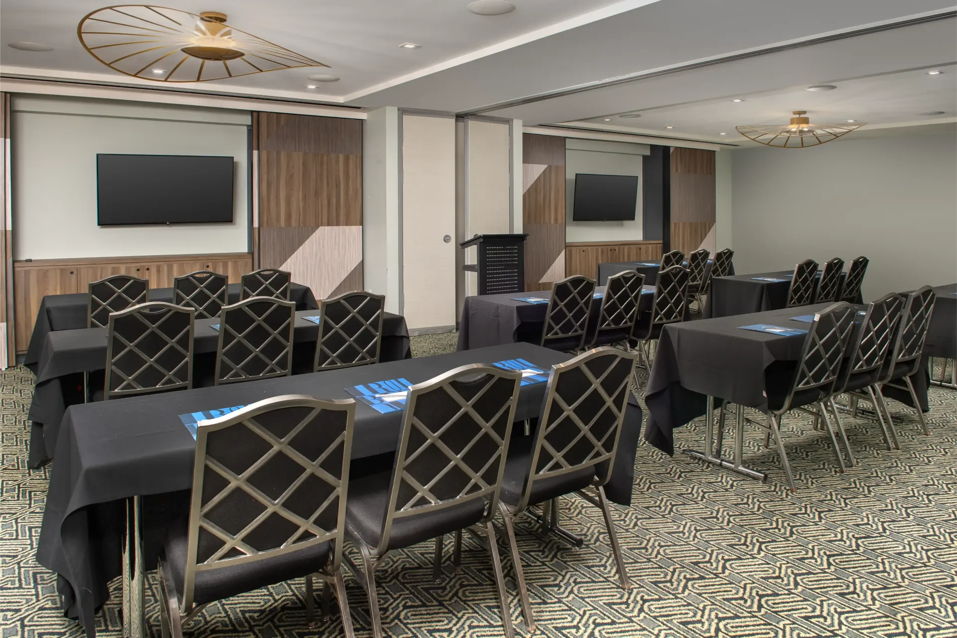 A conference room with tables and chairs and a flat screen tv.