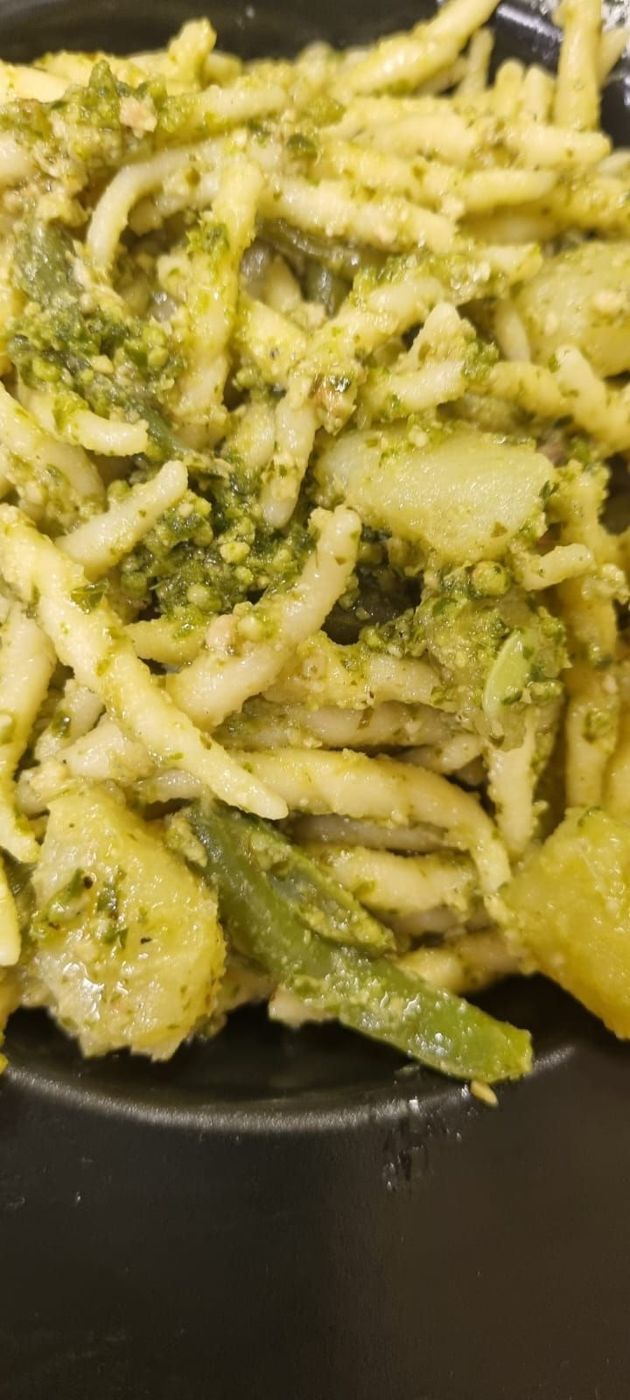 Primo piano di pasta condita con pesto 