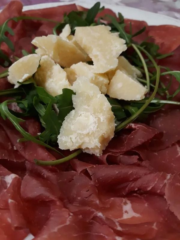 Affettati sottili con rucola e scaglie di parmigiano