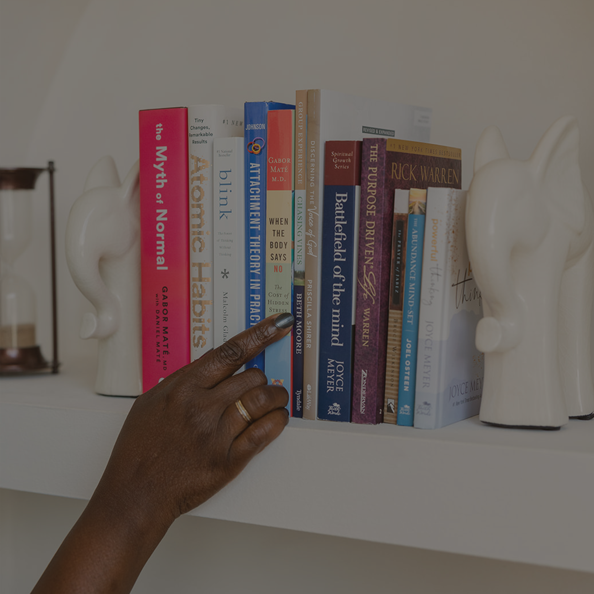 Hand pointing to books.