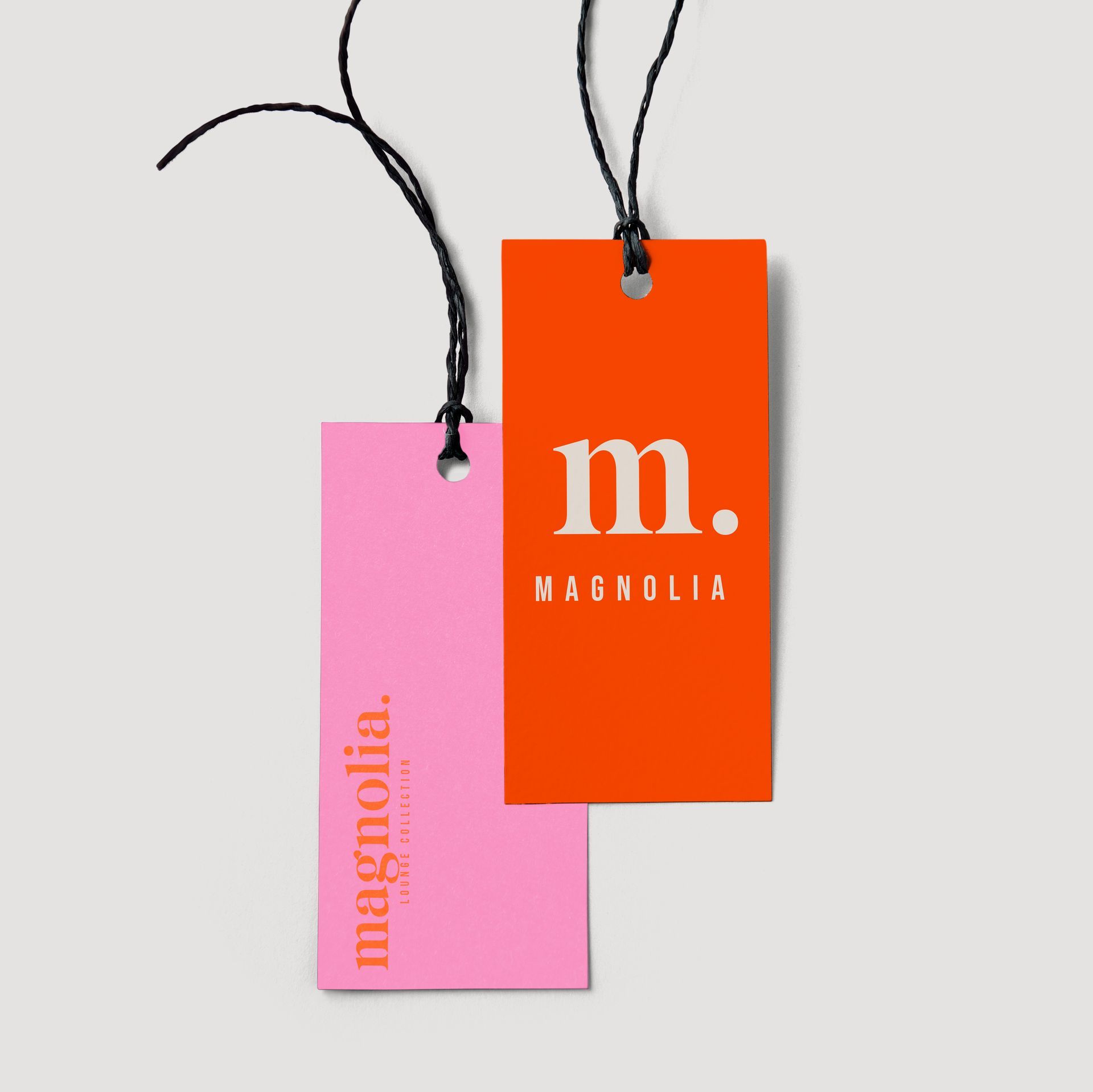 A pink and orange tag for magnolia hangs from a string