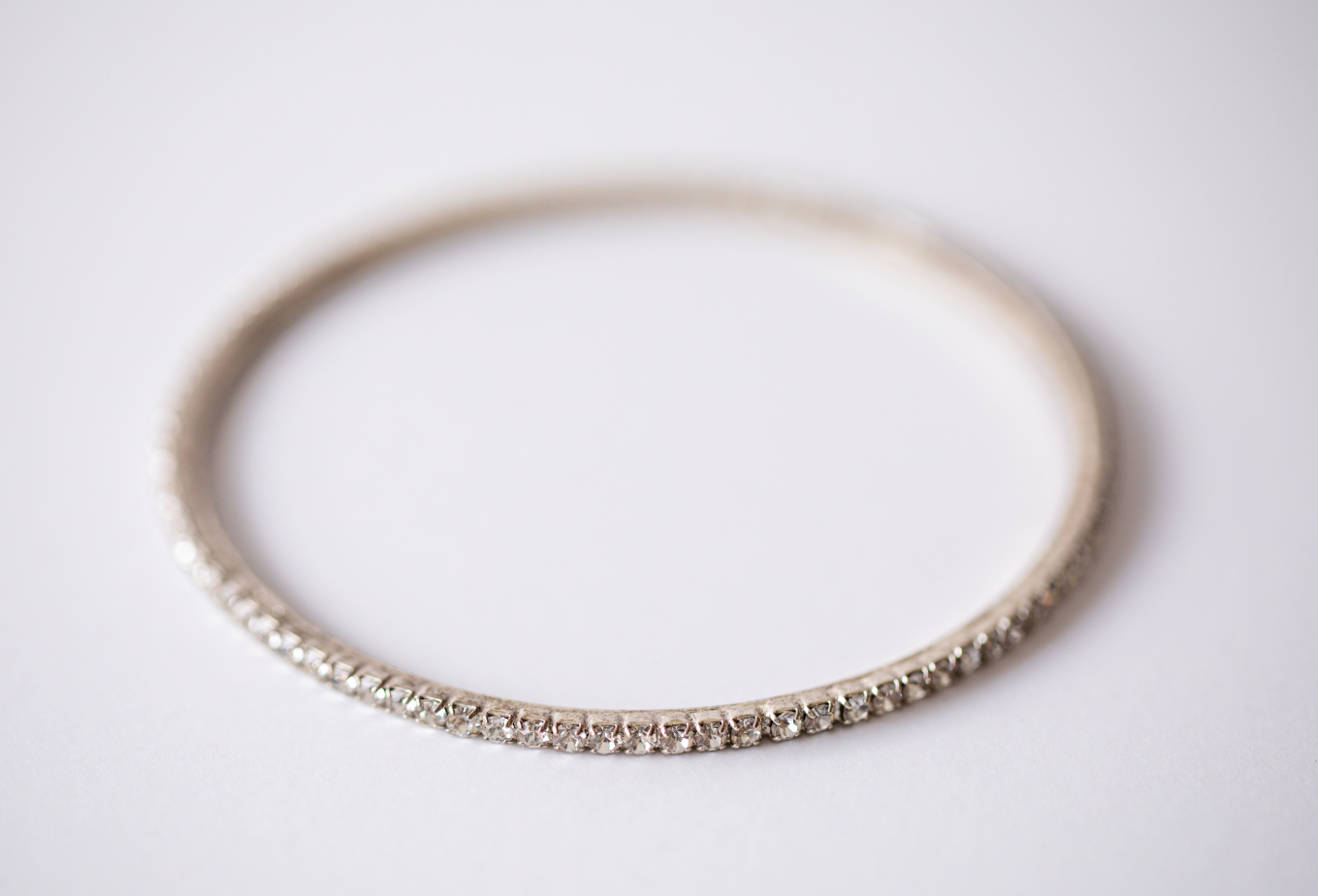 Thin diamond-studded gold ring on a white background