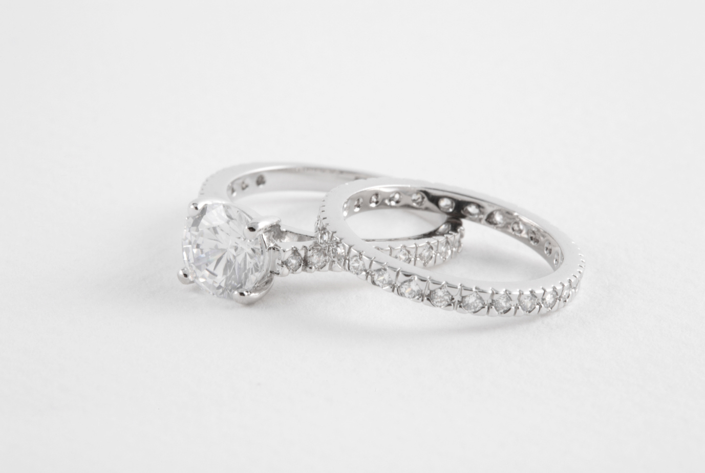 Diamond engagement ring with a solitaire and pavé band on a white background