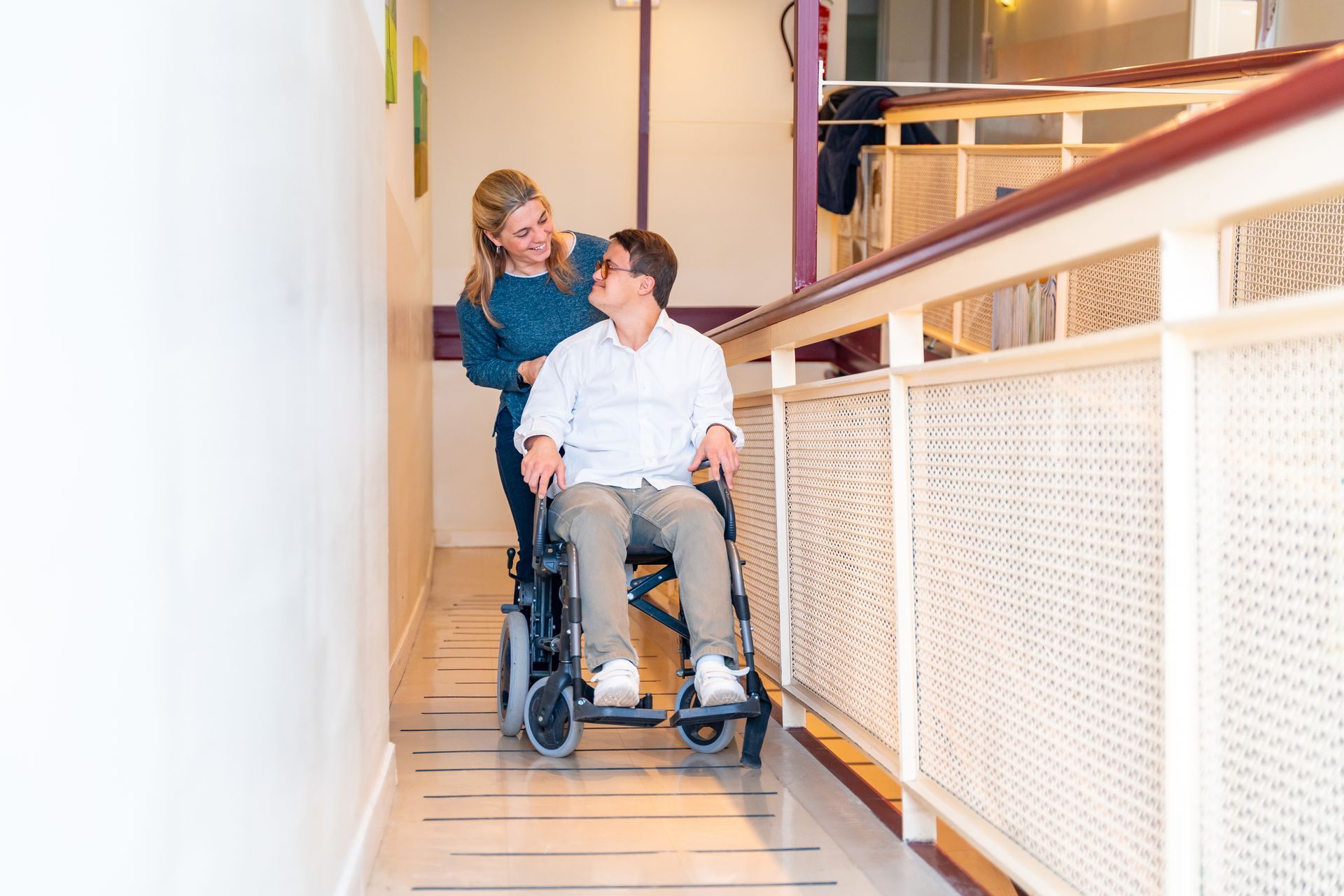 Care provider speaking with a disabled man seated in a wheelchair.