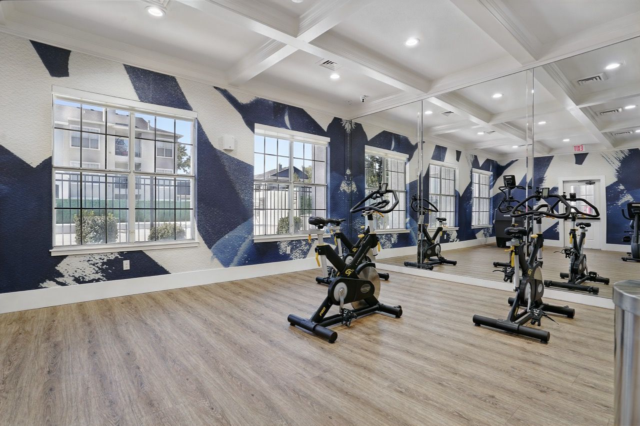 Indoor fitness center with stationary bikes and mirrored wall at Preston Hollow in Millcreek, UT.