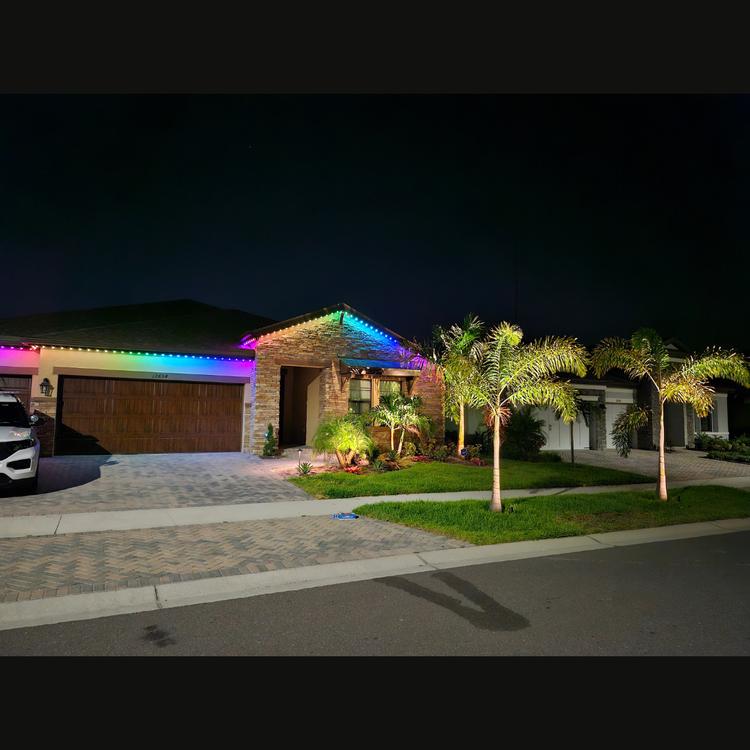 A house is lit up with rainbow lights at night.