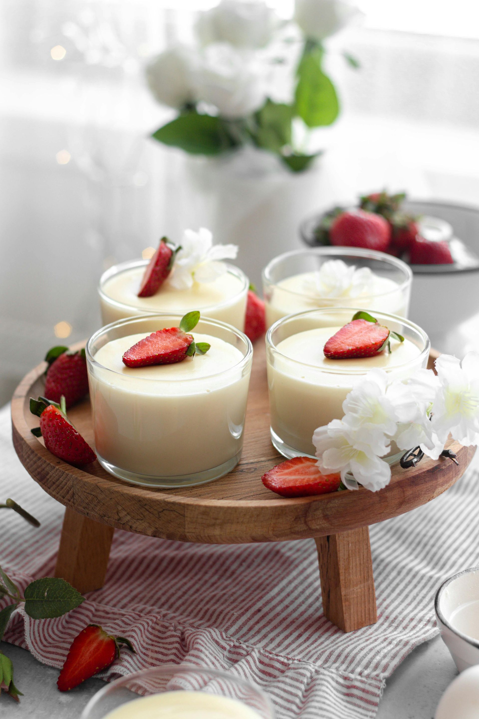 Delicious strawberry panna cotta made from milk products, served in glass cups with fresh fruit garnish.