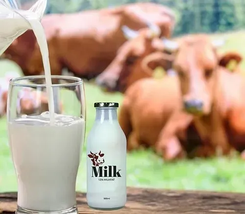 Fresh local milk poured into a glass with dairy cows in the background