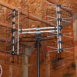Large indoor antenna mounted on a pole. The antenna has two mirrored sections with multiple metal rods and red tips.