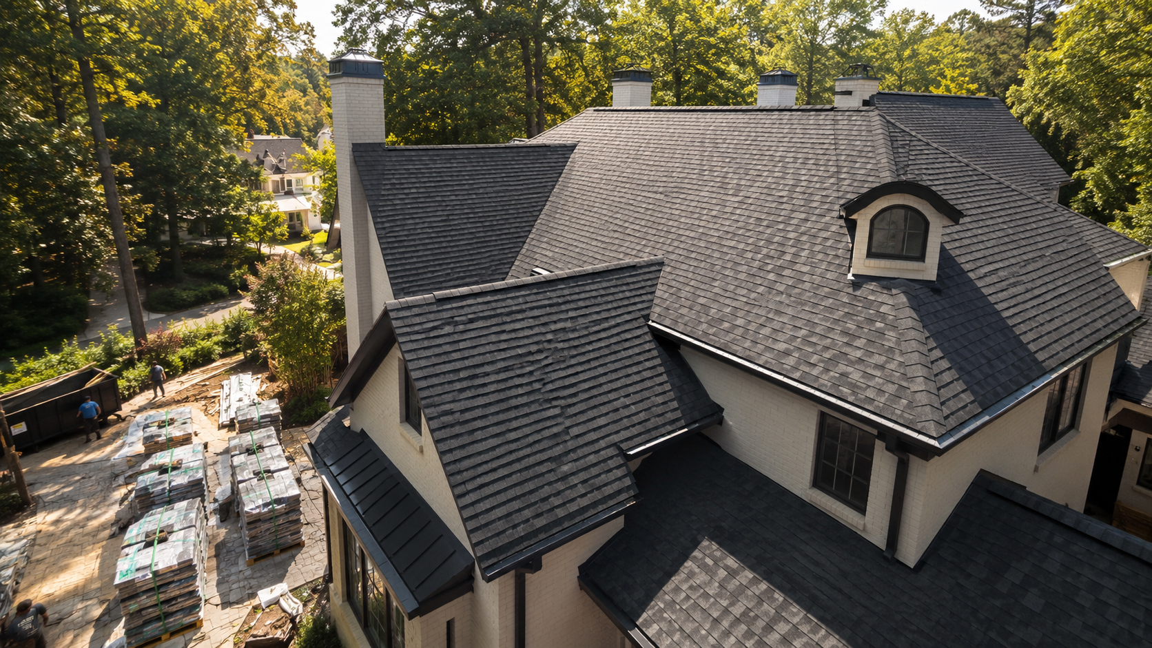 Aerial view of a gray shingled roof with scattered white debris and a blue tarp on the lawn.