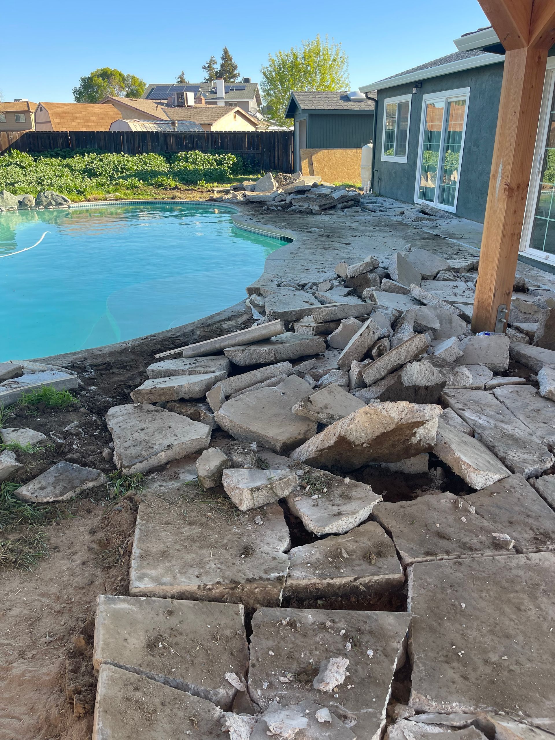 A pile of rocks is sitting next to a swimming pool.