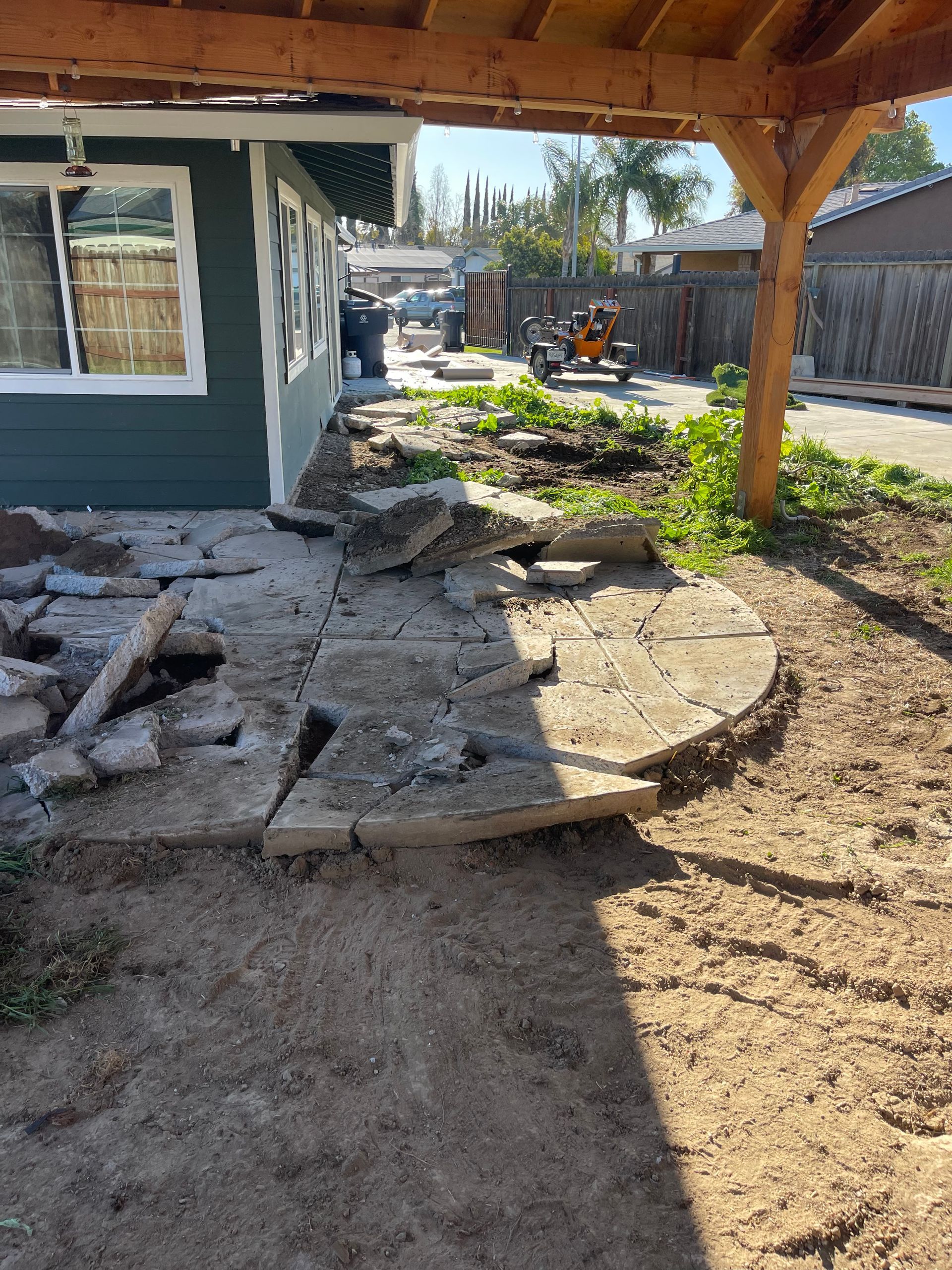 A house is being remodeled and a patio is being built in the backyard.
