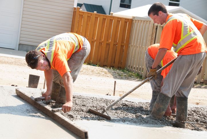 A group of construction workers are working on a sidewalk