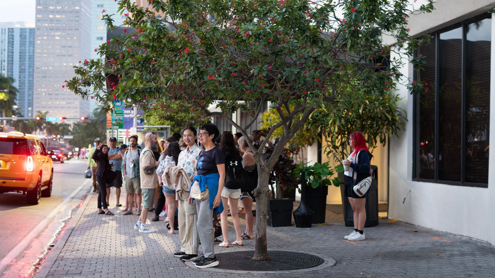 Guests gathering outside the Holiday Inn Downtown Miami for the Miami to Key West bus tour at sunrise, ready for a full-day Florida Keys adventure