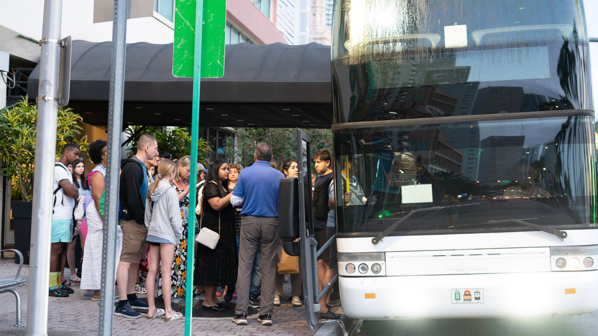 Group of people boarding a double-decker tour bus from Miami to Key West at a downtown Miam