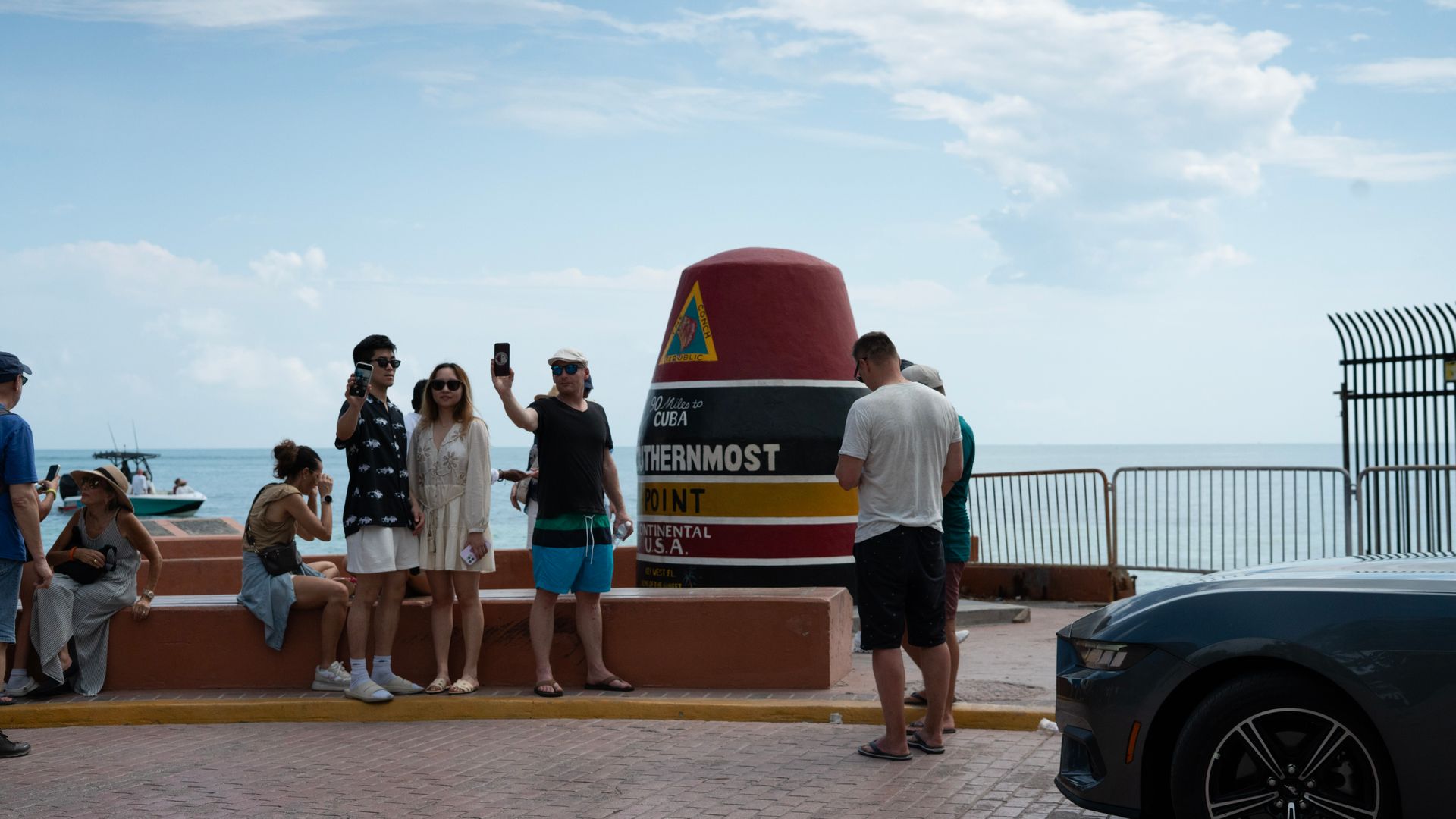 Visitors taking photos at the Southernmost Point landmark in Key West, a famous bucket list destination just 90 miles from Cuba