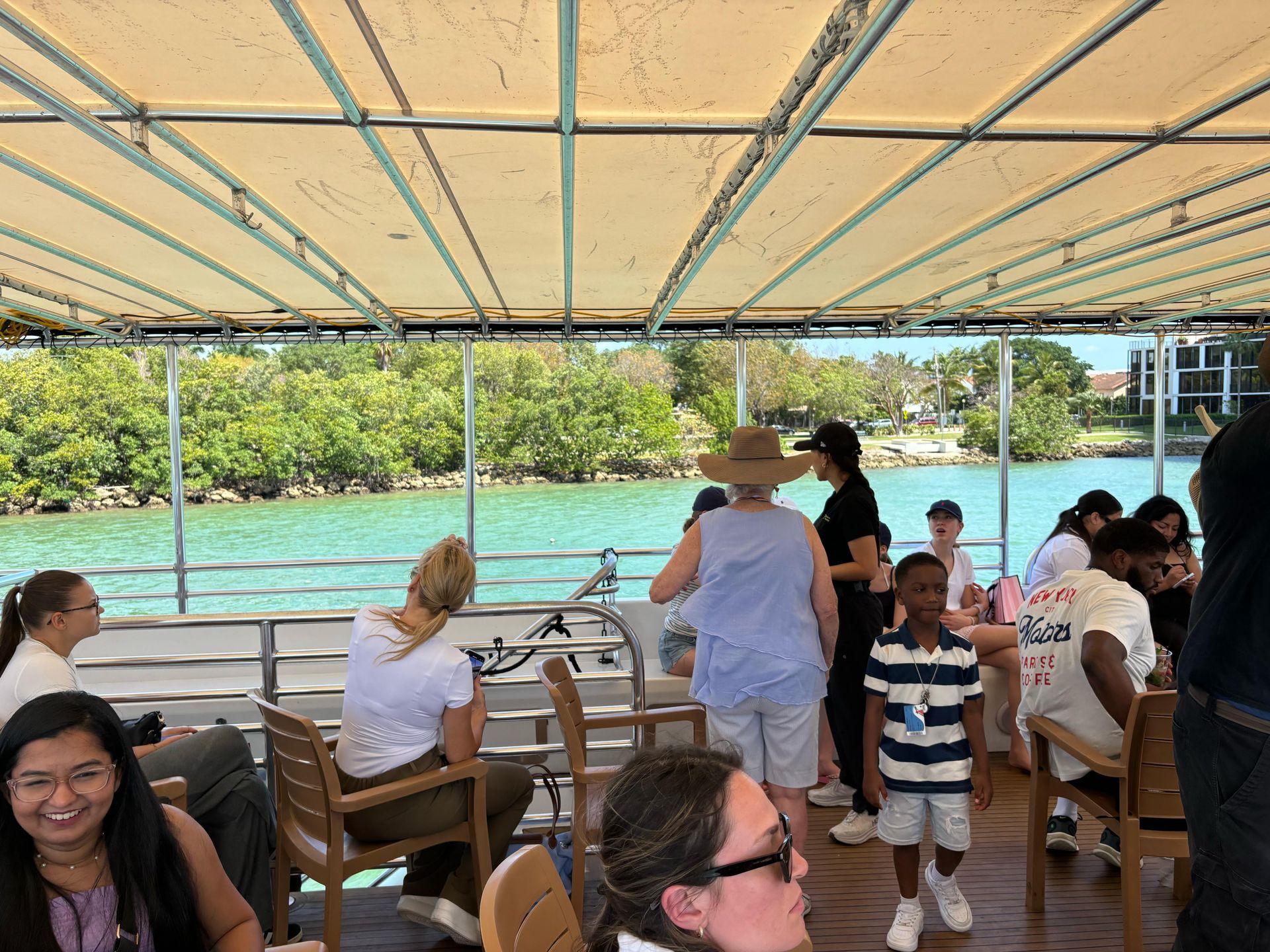 Guests relaxing on the open-air top deck during a Miami Mansion Boat Tour on Biscayne Bay
