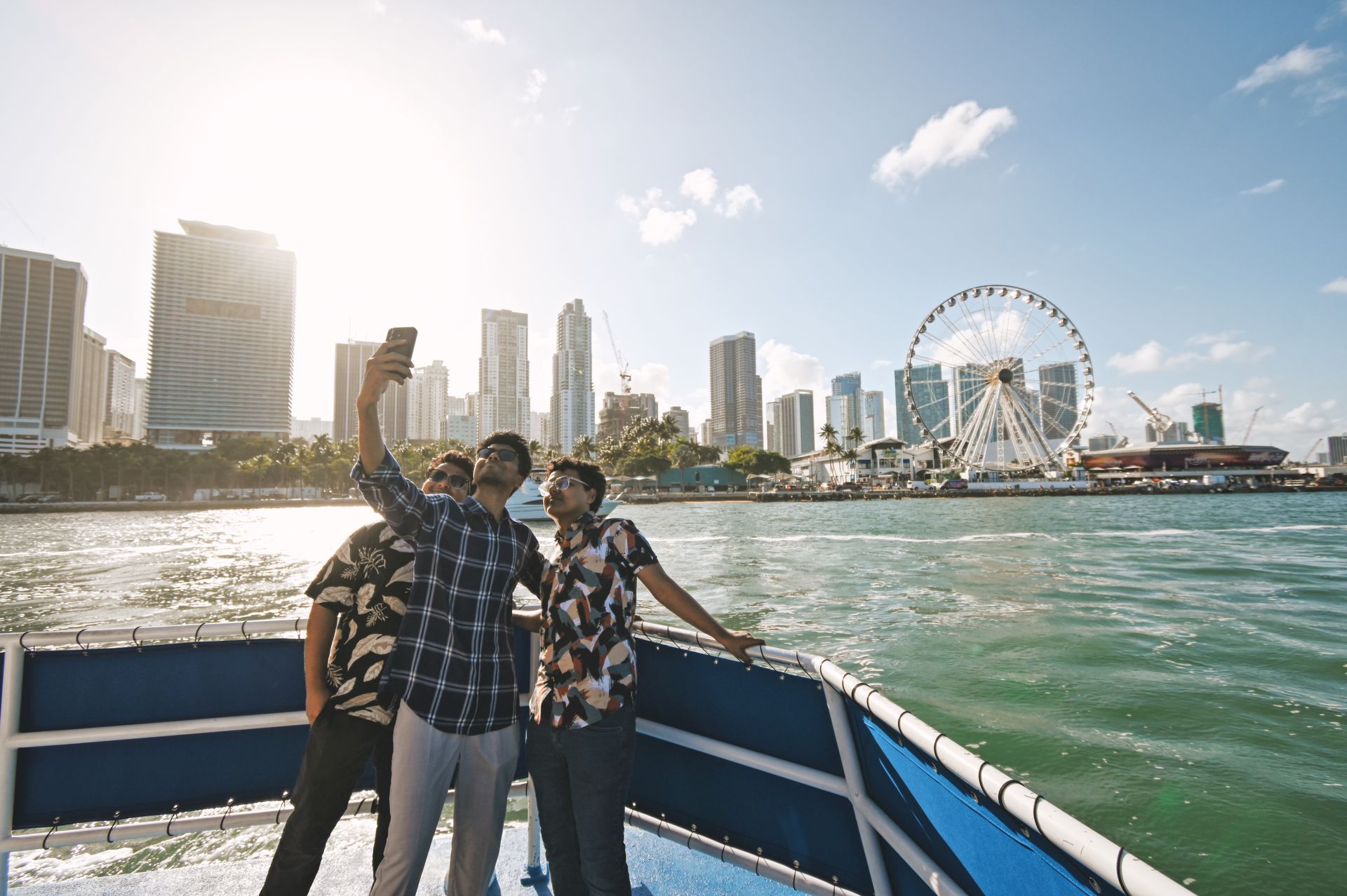 Group of Indian Visitors onboard the Bayside boat tour in Miami taking Pictures of them selfs on the front of the Miami Boat tour