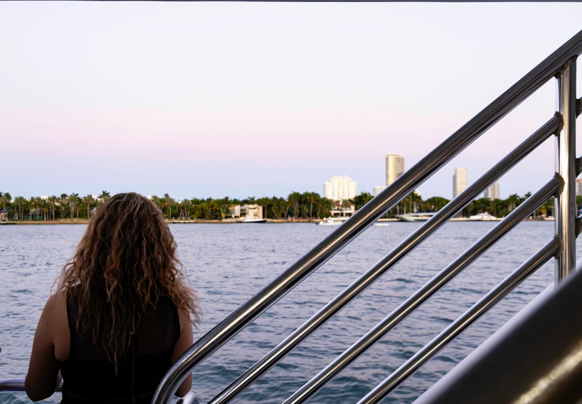 Guest enjoying sunset views of the Star Island mansions during a Miami Mansion Boat Tours