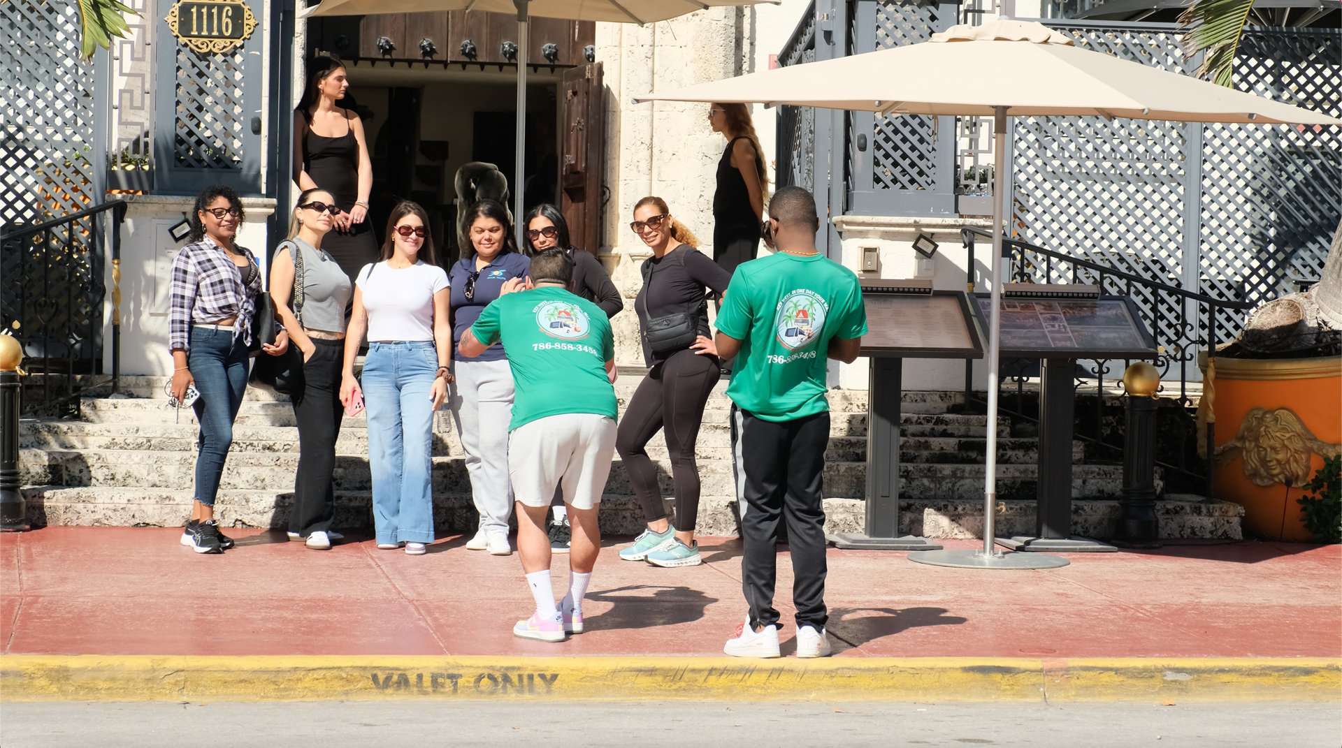 Passengers taking photos on the Miami Bus tour in front of the Versace Mansion