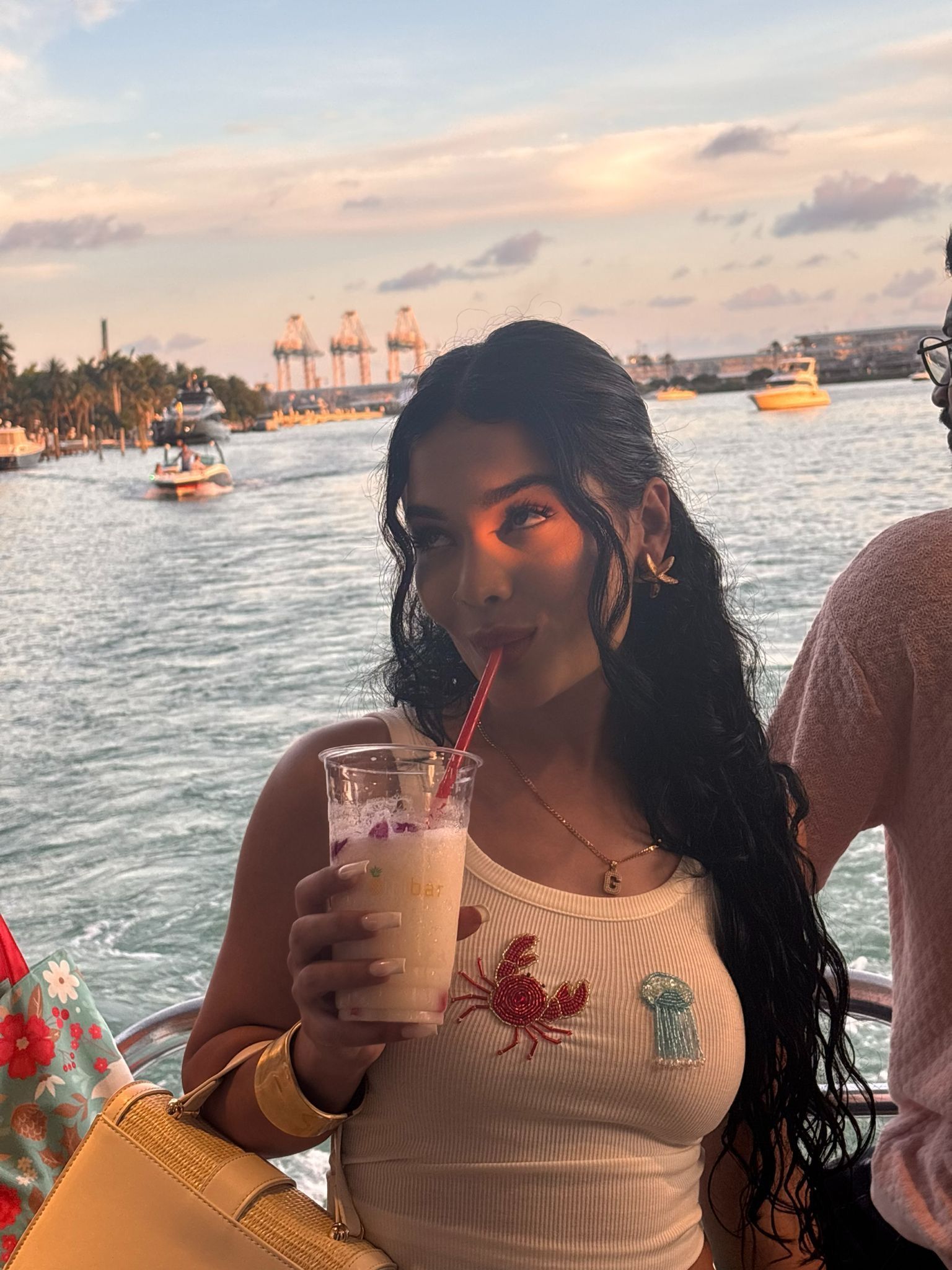 Woman enjoying a mojito on a boat tour in Miami with promo code while cruising past the skyline