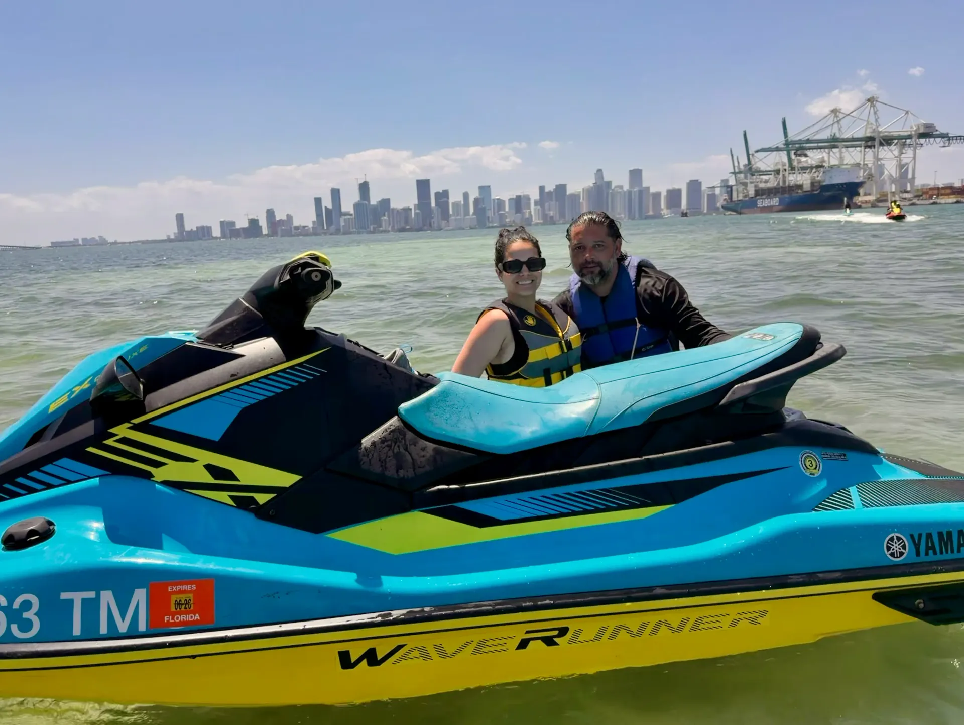 Couple enjoying a Tour Miami Jet Ski Rental experience with views of the Downtown Miami skyline and Biscayne Bay