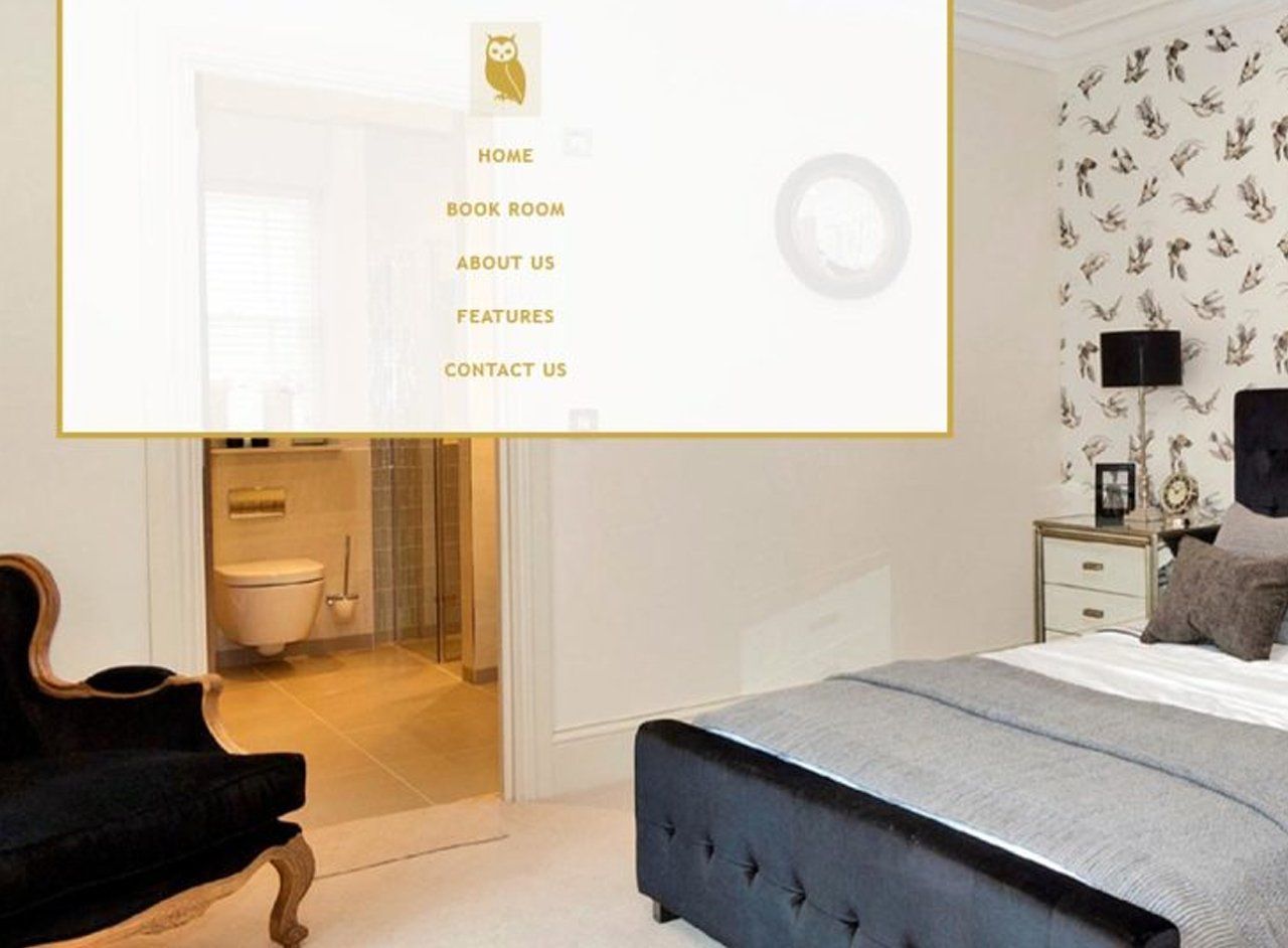A bedroom with a bed a chair and a toilet