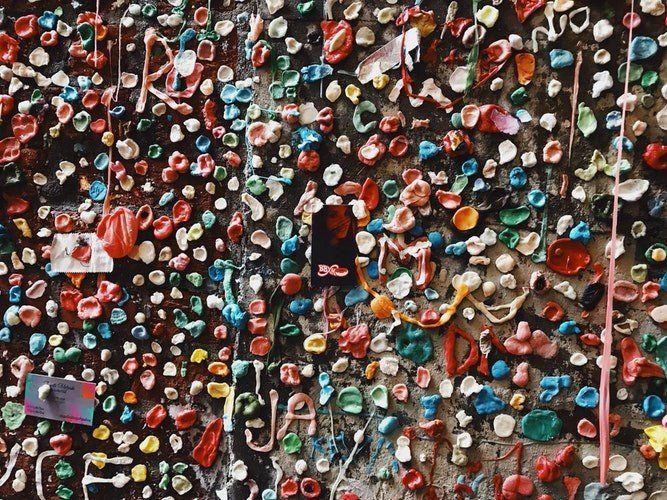 A wall covered in lots of colorful chewing gum.