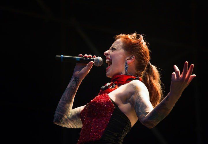 A woman in a red dress is singing into a microphone