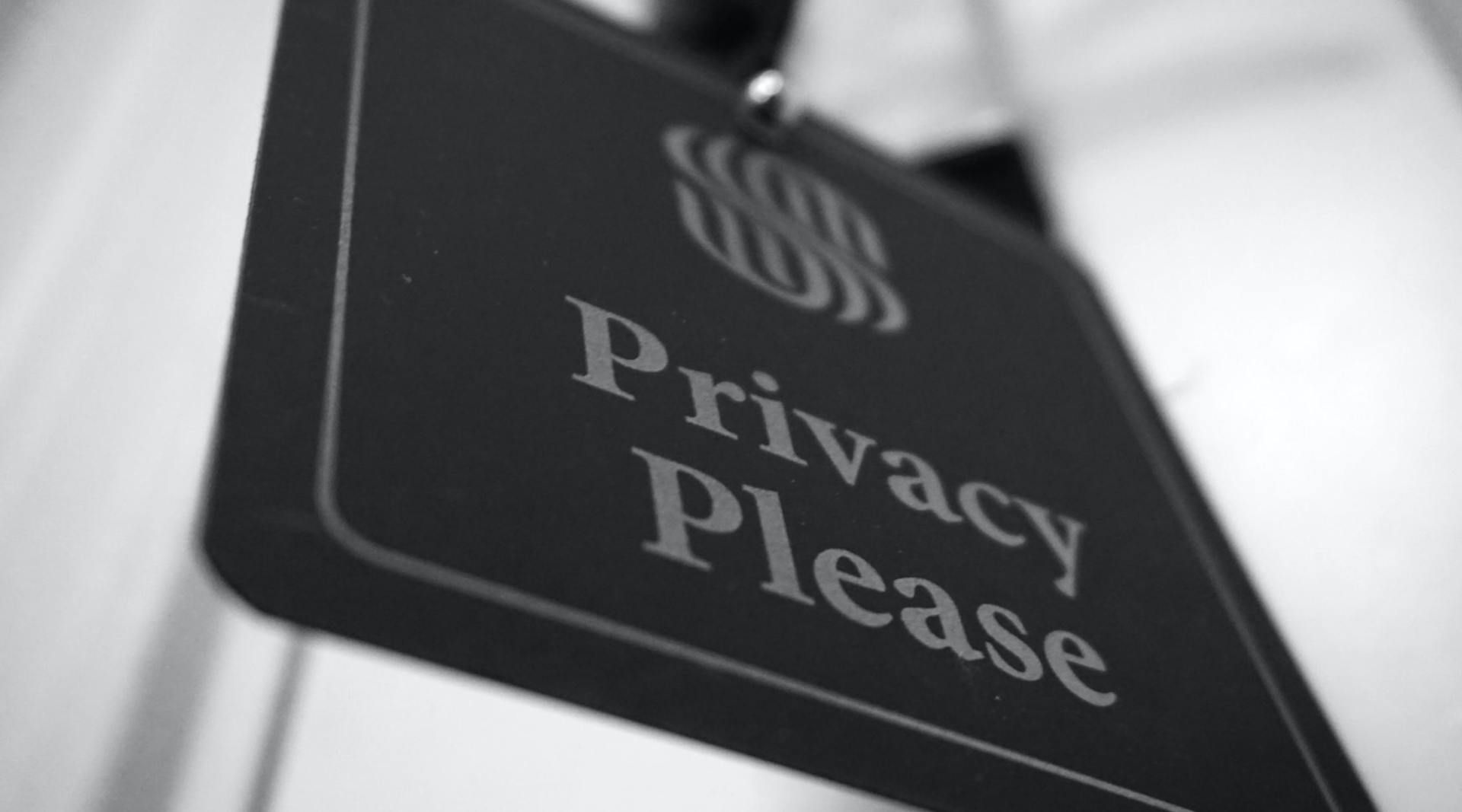 A black and white photo of a privacy please sign