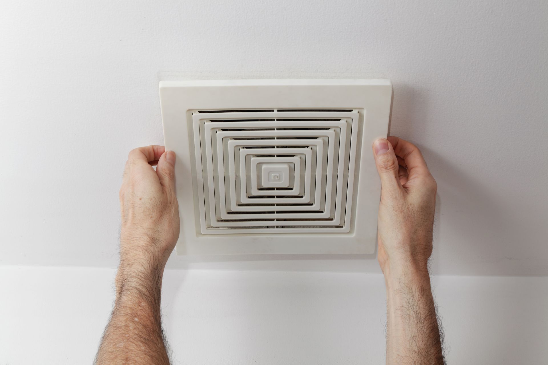 Installation d’un extracteur de salle de bain au plafond illustrant le système d’évacuation 