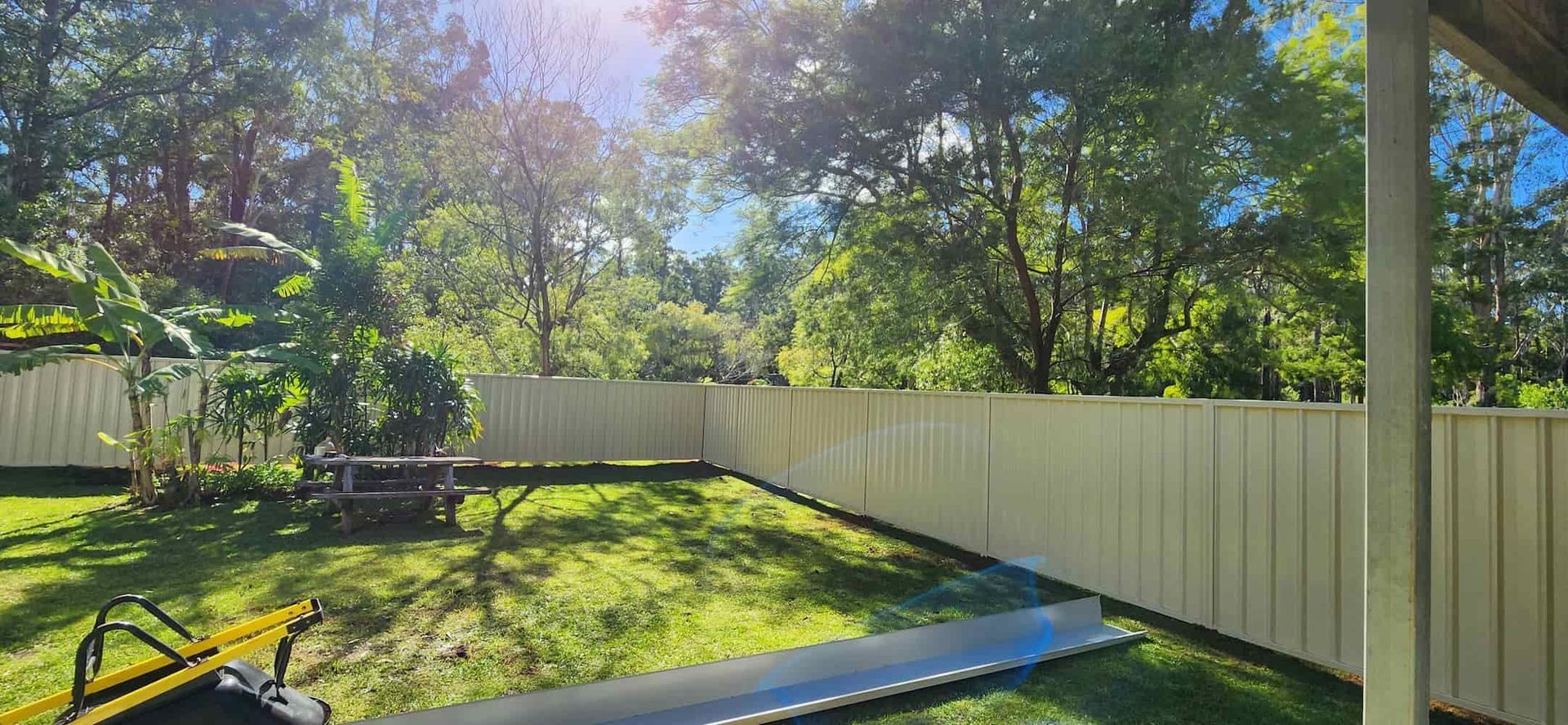 A Backyard With a White Fence and Trees in the Background — Harbour Fencing In Moonee Beach, NSW