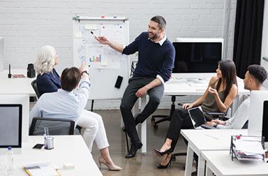 A man is giving a presentation to a group of people in an office.