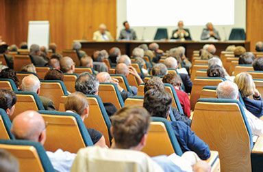 A large group of people are sitting in a lecture hall.