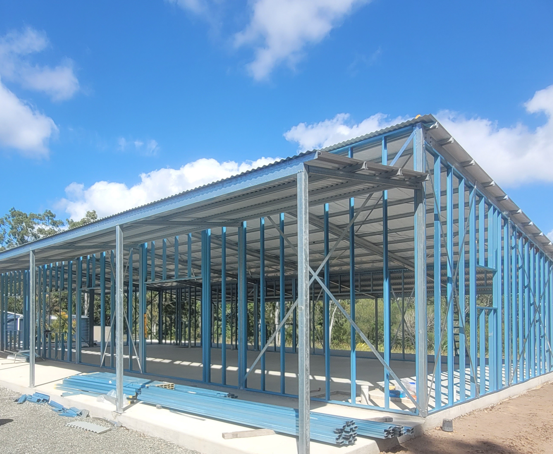 Construction site with steel frame of a building against a dusky sky — Steel Homes Australia in Branyan, QLD