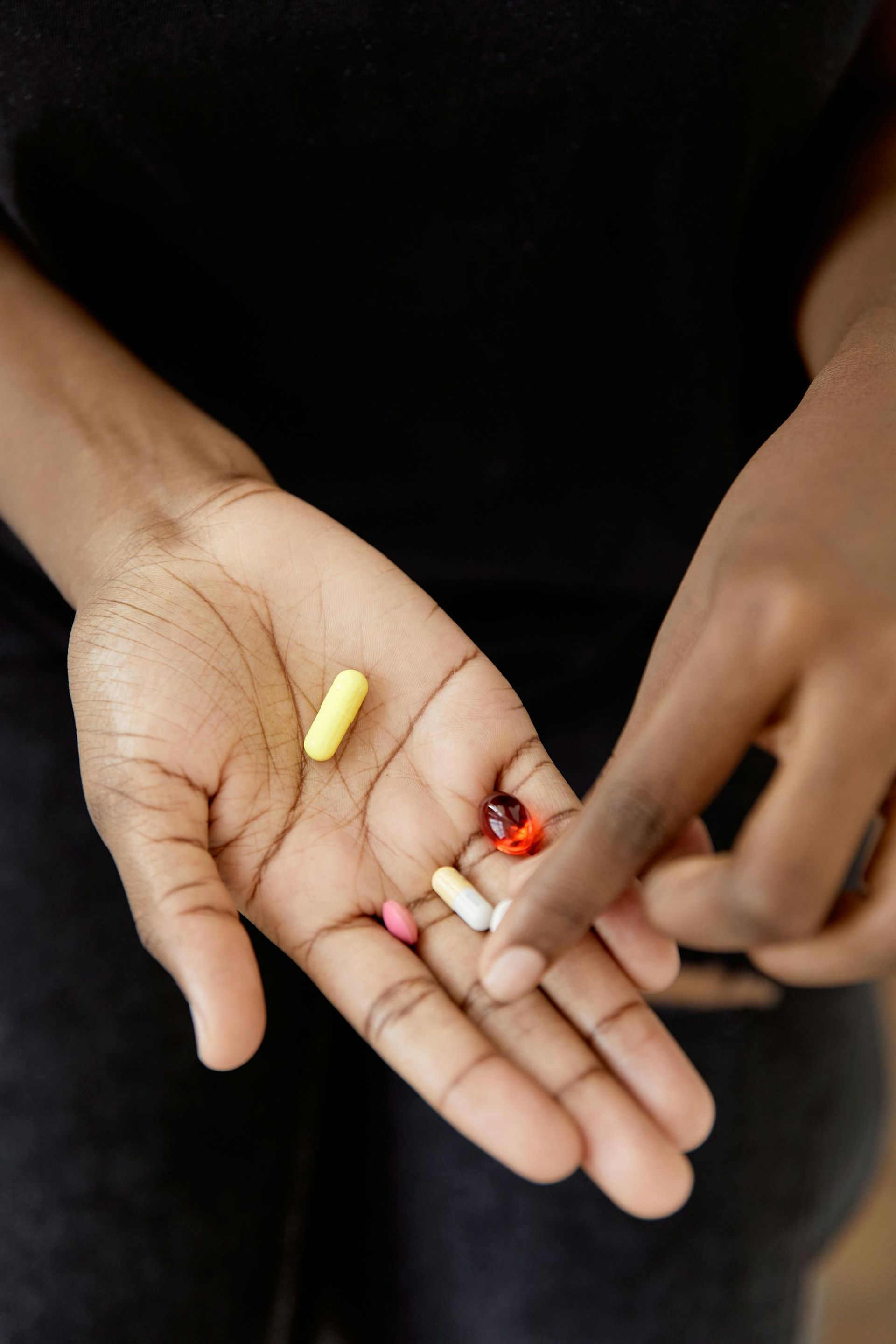A person is taking a pill from another person 's hand.