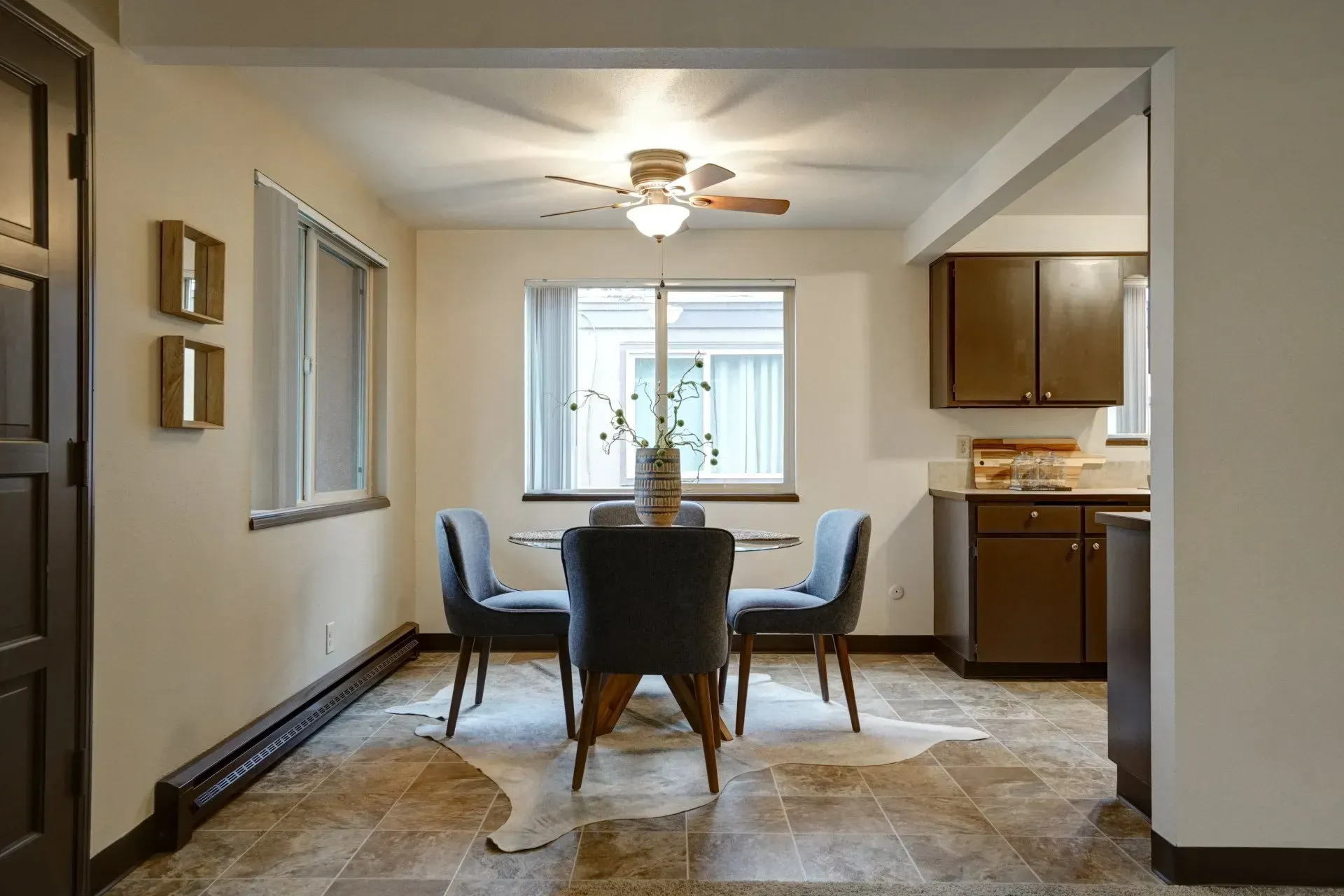 Dining room with a table, four chairs, and a kitchen visible in the background.